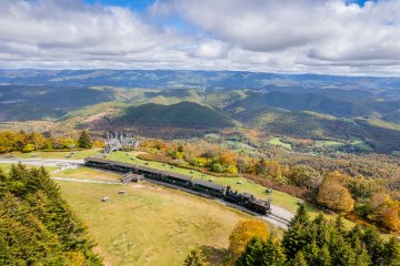 a train on a track with a mountain in the background