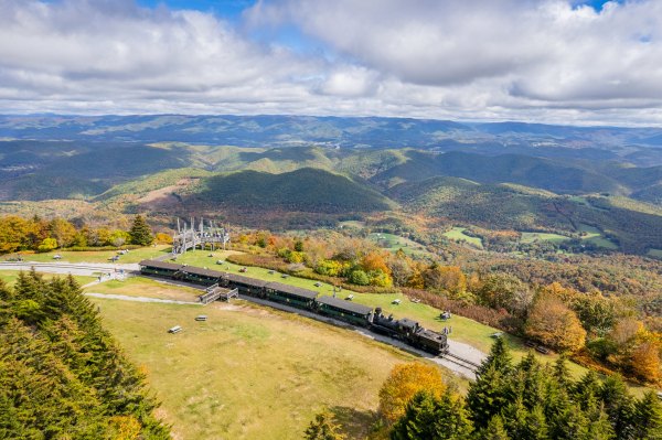 a train on a track with a mountain in the background