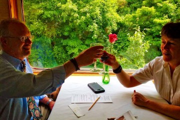 a man sitting at a table with wine glasses