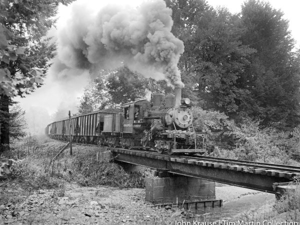 a steam train on a track with smoke coming out of it