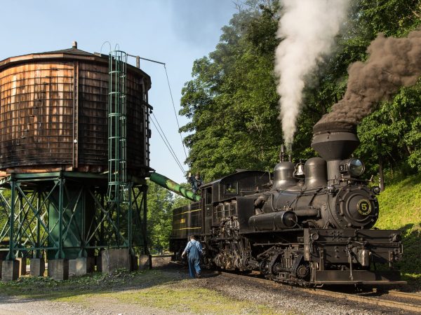 a steam train on a track with smoke coming out of it