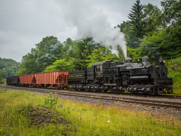 a large long train on a track with smoke coming out of it